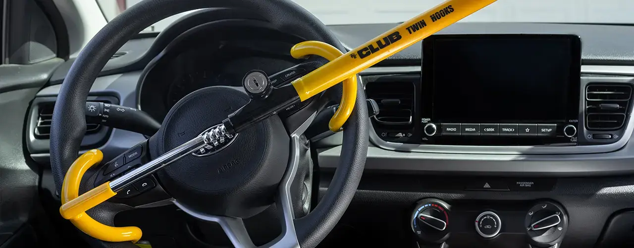 A steering wheel featuring a yellow handle, representing a steering wheel lock designed to enhance vehicle security.