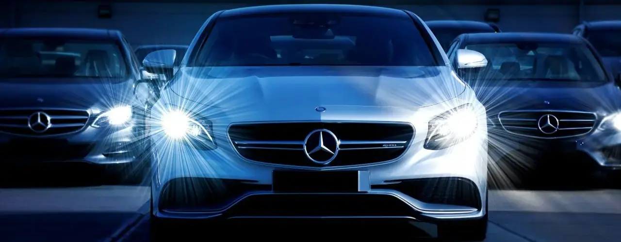 A sleek Mercedes-Benz parked with with illuminated front LED lights