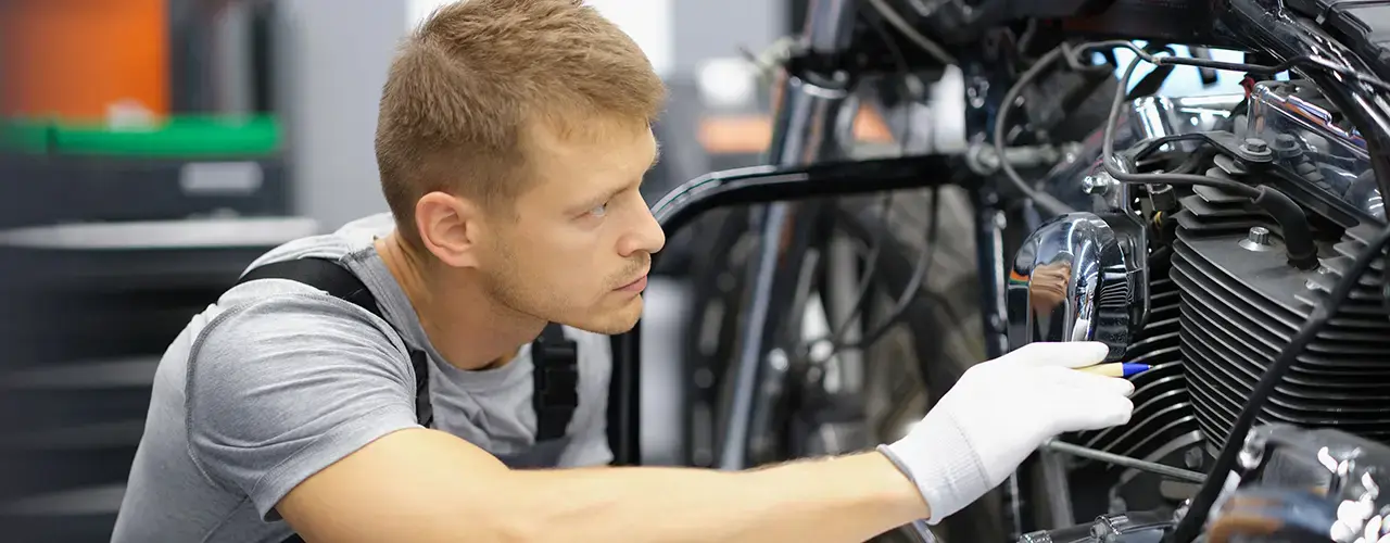 A man repairs a motorcycle.