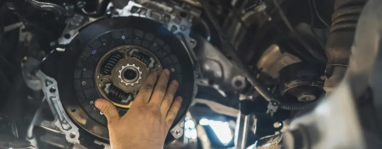 A person is repairing a car clutch system.