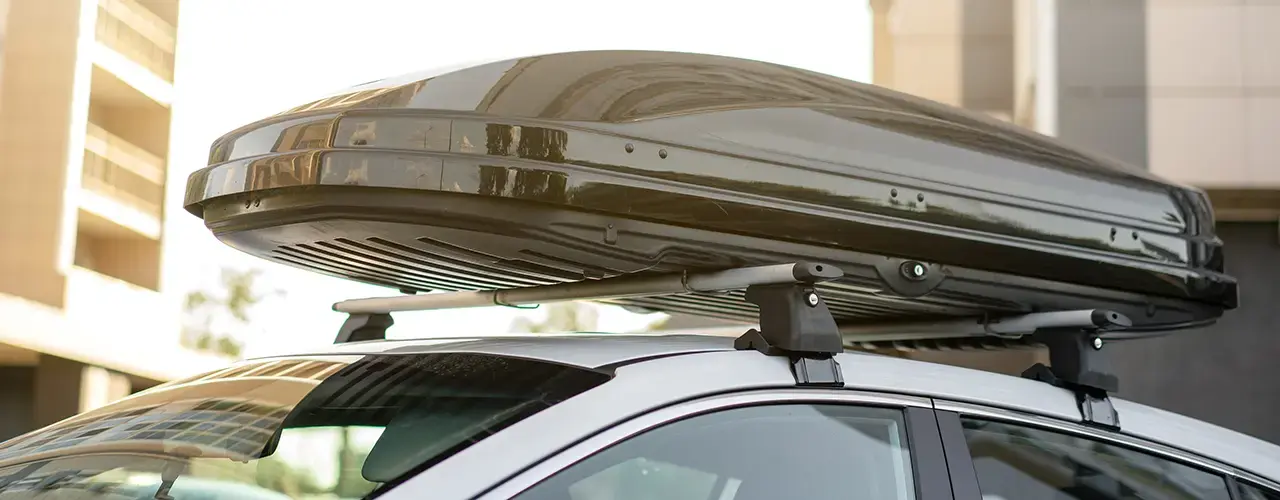 A car equipped with a roof box on top, ready for spring and summer travel adventures.